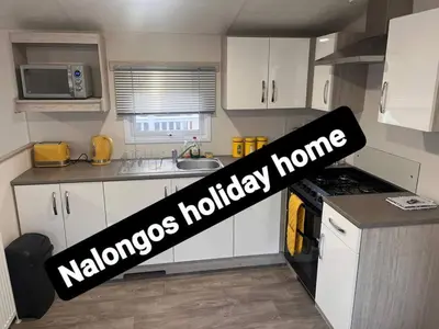a kitchen with a sign that reads nanos holiday home at FV006 NALONGOS HOLIDAY HOME in Saint Osyth