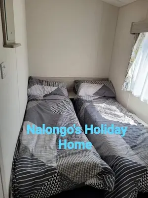 two beds in a small bedroom with the words melbourne holiday home at FV006 NALONGOS HOLIDAY HOME in Saint Osyth