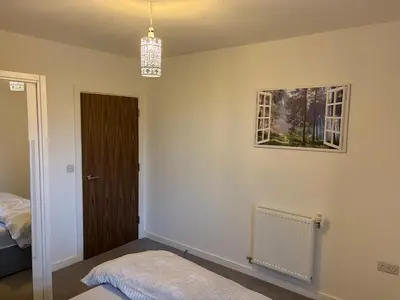 a bedroom with a bed and a picture on the wall at Spacious Apartment in the Heart of Chelmsford in Chelmsford