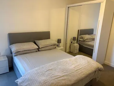 a bedroom with two beds and a mirror at Spacious Apartment in the Heart of Chelmsford in Chelmsford