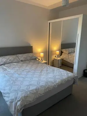 a bedroom with a large bed and two lamps at Spacious Apartment in the Heart of Chelmsford in Chelmsford