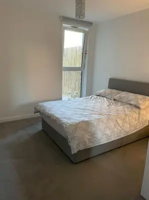 a bed in a room with a window at Spacious Apartment in the Heart of Chelmsford in Chelmsford