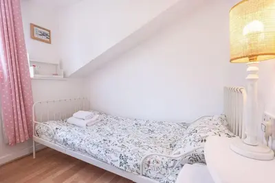 a small bedroom with a bed and a table at Lilac Cottage, Wenhaston in Halesworth