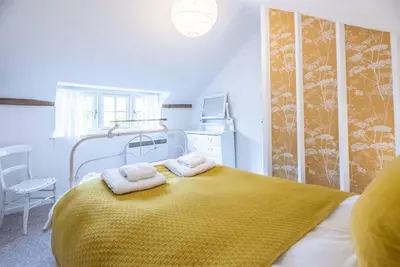 a bedroom with a bed with two towels on it at Lilac Cottage, Wenhaston in Halesworth