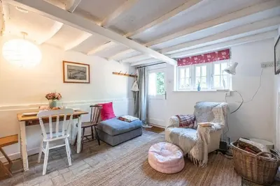 a living room with a table and a chair and a desk at Lilac Cottage, Wenhaston in Halesworth
