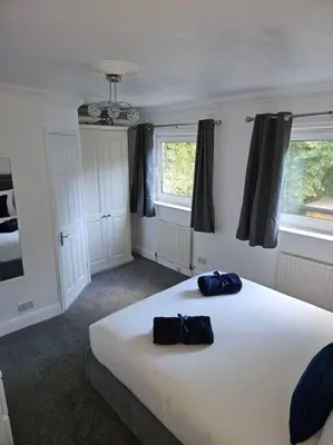 a bedroom with a large white bed with two bags on it at Spacious 4 Bedroom, Free Parking, Sleeps 7 in Havering atte Bower