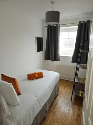 a bedroom with a bed and a ladder and a window at Spacious 4 Bedroom, Free Parking, Sleeps 7 in Havering atte Bower