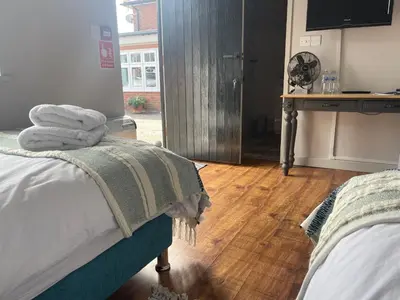 a bedroom with two beds with towels on them at The Courtyard Rooms in Brightlingsea