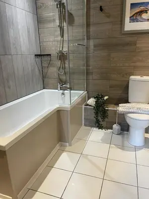 a bathroom with a tub and a toilet in it at The Courtyard Rooms in Brightlingsea