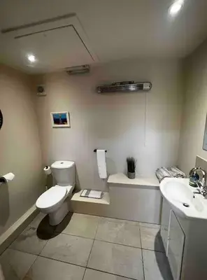 a bathroom with a toilet and a sink at The Courtyard Rooms in Brightlingsea