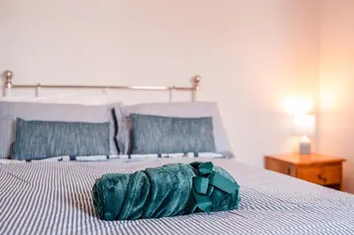 a green bag sitting on top of a bed at SuffStay in Ipswich
