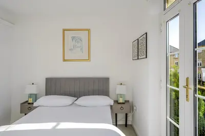 a white bedroom with a bed and a window at Luxurious 3 Bed House with Free Parking, Sky TV, Movies & Netflix in Braintree