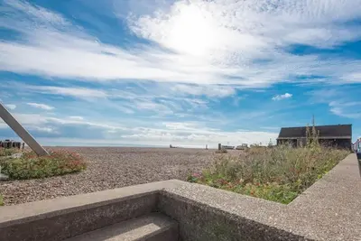 a view of a beach with a house and the ocean at Seaway Cottage, Aldeburgh in Aldeburgh