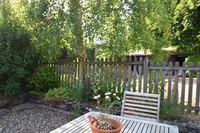 a wooden bench in front of a wooden fence at The Red Shed Entire home for 2 Private garden and parking 2 miles from Bury St Edmunds in Whepstead