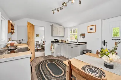 a kitchen with white cabinets and a table in a kitchen at The Red Shed Entire home for 2 Private garden and parking 2 miles from Bury St Edmunds in Whepstead