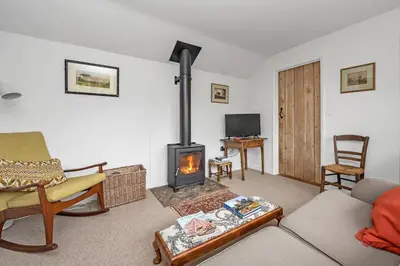 a living room with a wood stove in it at The Red Shed Entire home for 2 Private garden and parking 2 miles from Bury St Edmunds in Whepstead
