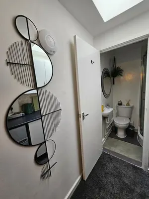 a bathroom with a mirror next to a toilet at Luxury Studio Stevenage in Stevenage