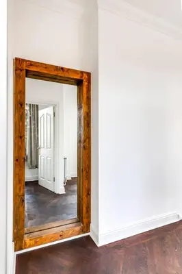 a mirror with a wooden frame in a room at Entire 3 Bedroom House Contractors Families Relocators in Ware