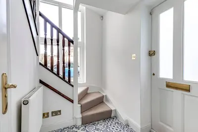 a hallway with white walls and stairs with a glass door at Entire 3 Bedroom House Contractors Families Relocators in Ware