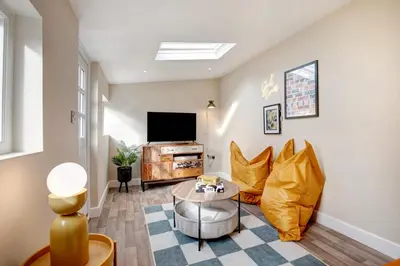 a living room with a couch and a tv at Beautifully refurbished cottage in lower Wivenhoe. in Wivenhoe
