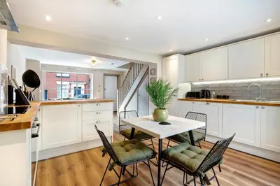 a kitchen and dining room with a table and chairs at Beautifully refurbished cottage in lower Wivenhoe. in Wivenhoe