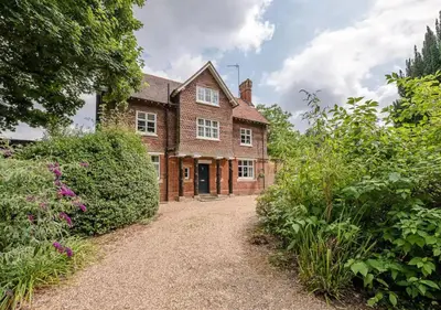 an old brick house with a garden in front of it at Gardeners Cottage - Nowton Park in Bury Saint Edmunds