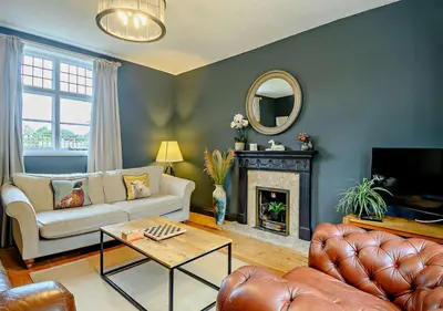 a living room with a couch and a fireplace at Gardeners Cottage - Nowton Park in Bury Saint Edmunds