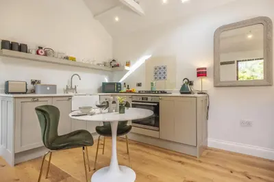 a kitchen with a table and chairs and a sink at Weavers Mark Cottage in Diss