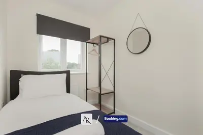 a bedroom with a bed and a mirror on the wall at Luxury House By AR Properties Short Lets & Serviced Accommodation Colchester in Colchester