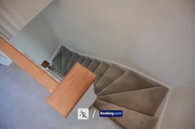 an empty room with stairs and a wooden table at Luxury House By AR Properties Short Lets & Serviced Accommodation Colchester in Colchester