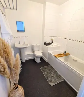 a white bathroom with a toilet and a tub and a sink at 3-Bed, Sleeps 6, 1 Bath, Parking, WiFi in Ipswich