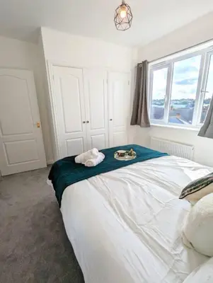 a bedroom with a large bed with a towel on it at 3-Bed, Sleeps 6, 1 Bath, Parking, WiFi in Ipswich