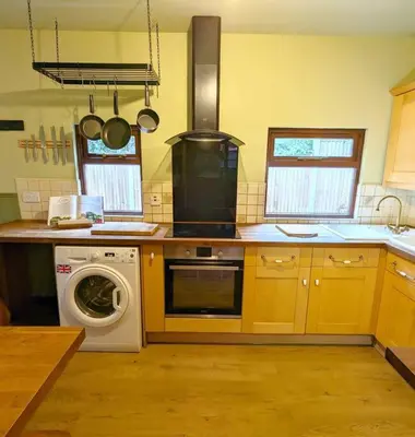 a kitchen with a washing machine and a washer at 3-Bed, Sleeps 6, 1 Bath, Parking, WiFi in Shalford