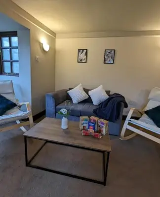 a living room with a blue couch and a coffee table at 3-Bed, Sleeps 6, 1 Bath, Parking, WiFi in Shalford