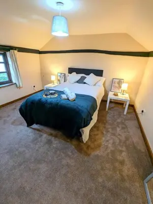 a bedroom with a large bed with a blue blanket at 3-Bed, Sleeps 6, 1 Bath, Parking, WiFi in Shalford