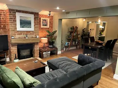 a living room with a couch and a fireplace at Hall Farm Cottage, Barham in Ipswich