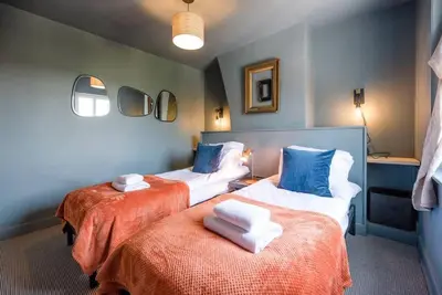 a room with two beds with towels on them at Key Cottage, Orford in Woodbridge