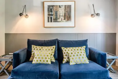 a blue couch with yellow pillows in a living room at Key Cottage, Orford in Woodbridge