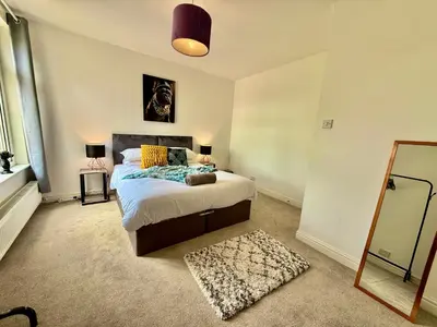 a bedroom with a bed and a mirror at 6 Bedroom House - DISC0UNTS - Pool Table, Parking, Contractors, Group, Family in Colchester