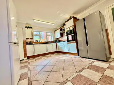 a kitchen with a refrigerator and a tile floor at 6 Bedroom House - DISC0UNTS - Pool Table, Parking, Contractors, Group, Family in Colchester