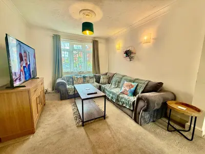 a living room with a couch and a tv at 6 Bedroom House - DISC0UNTS - Pool Table, Parking, Contractors, Group, Family in Colchester