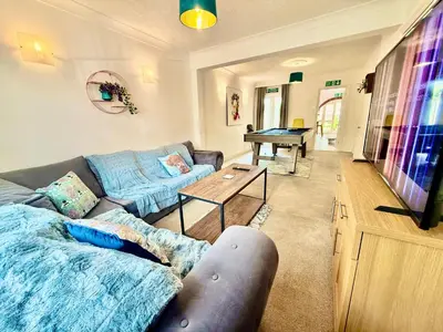 a living room with a couch and a table at 6 Bedroom House - DISC0UNTS - Pool Table, Parking, Contractors, Group, Family in Colchester