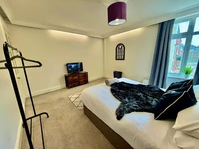 a bedroom with a bed and a tv in it at 6 Bedroom House - DISC0UNTS - Pool Table, Parking, Contractors, Group, Family in Colchester