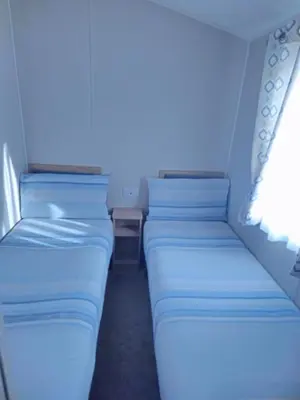 two beds in a small room with blue lighting at Ultimate serene getaway in East Mersea