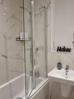 a white bathroom with a shower and a sink at Modern 2bedroom House in Ipswich Suffolk in Ipswich