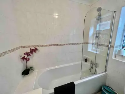 a bathroom with a tub and a vase of flowers at Fig Tree Central Cambridge Apartment Walk to Colleges & River Cam in Cambridge