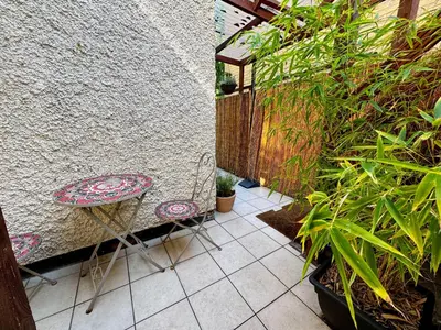 a patio with a chair and a table and some plants at Fig Tree Central Cambridge Apartment Walk to Colleges & River Cam in Cambridge