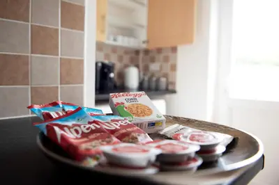 a table with some chips and snacks on it at Tillyard Retreat, Ground Floor Apartment Cambridge in Cherry Hinton