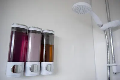 a row of thermos bottles on a shelf in a shower at Tillyard Retreat, Ground Floor Apartment Cambridge in Cherry Hinton