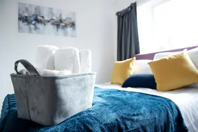 a bag of towels sitting on a bed at Tillyard Retreat, Ground Floor Apartment Cambridge in Cherry Hinton